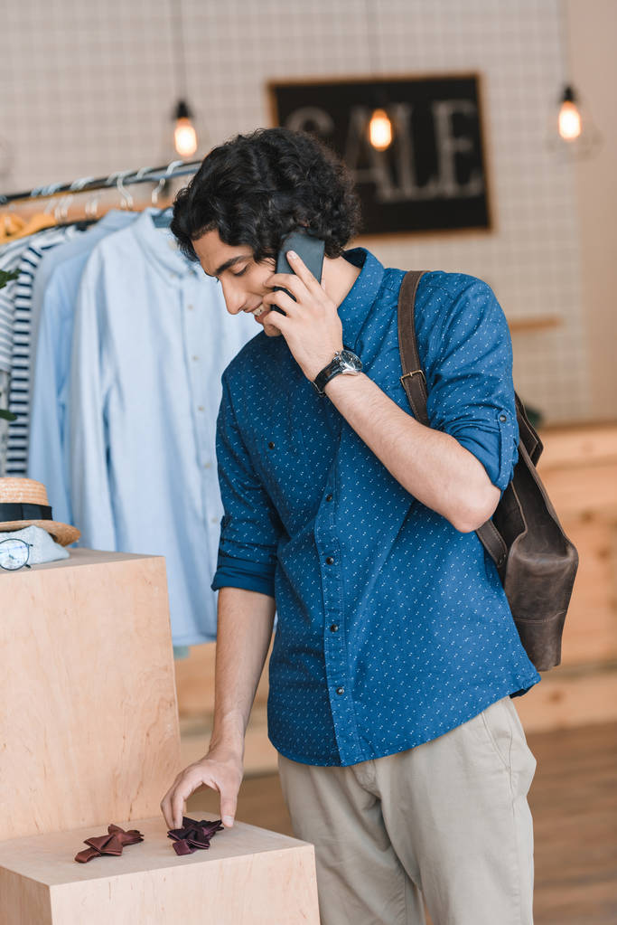 Mann telefoniert beim Einkaufen mit Smartphone - Foto, Bild