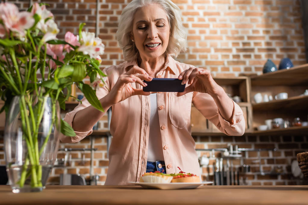 Kobieta, fotografowanie talerz z jedzeniem w kuchni - Zdjęcie, obraz
