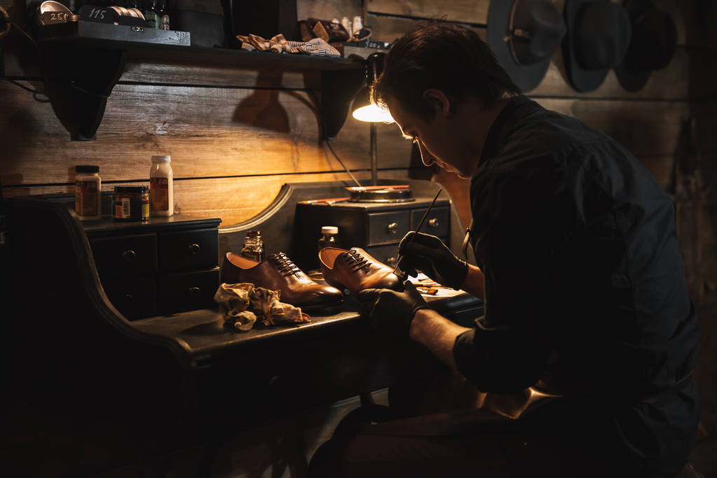 Handsome man shoemaker at footwear workshop. - Photo, Image