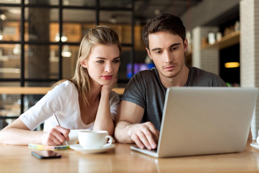 pareja trabajando en el ordenador portátil en la cafetería
 - Foto, imagen