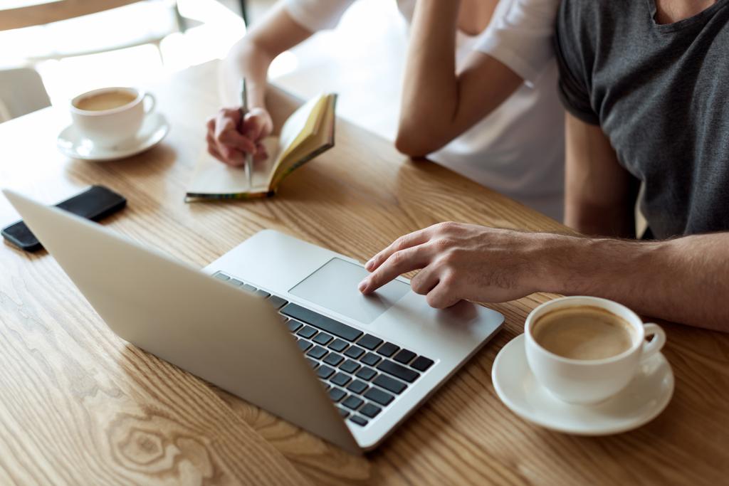 пара работающих на ноутбуке в кафе
 - Фото, изображение