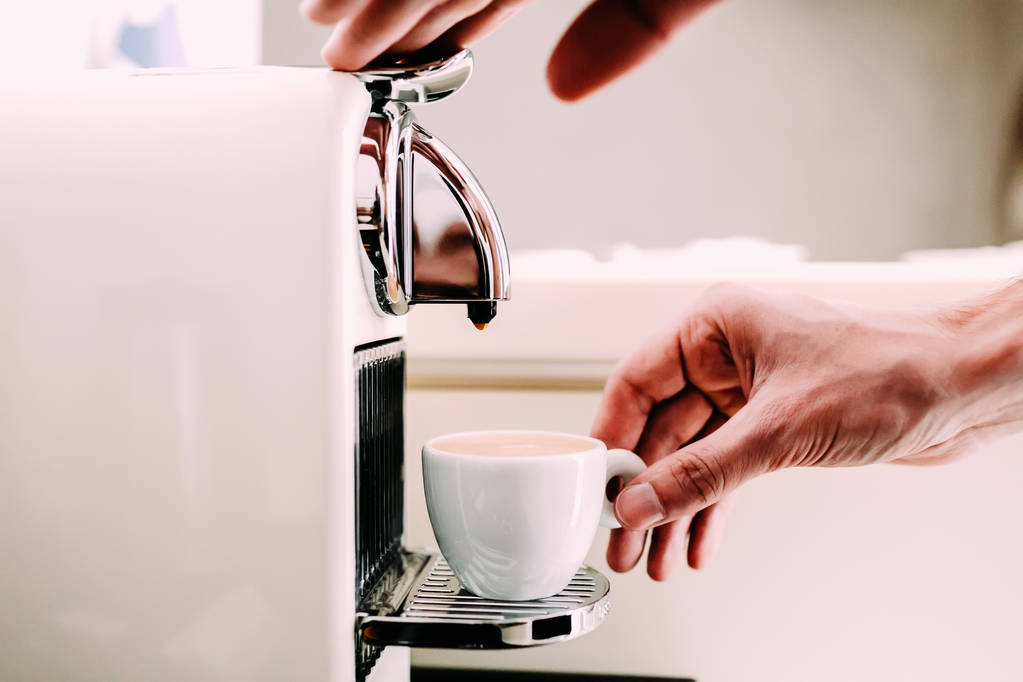 Primer plano de la mano de barista elaborando café con una máquina de café. Mano de hombre con una taza de café fresco con espuma
 - Foto, Imagen
