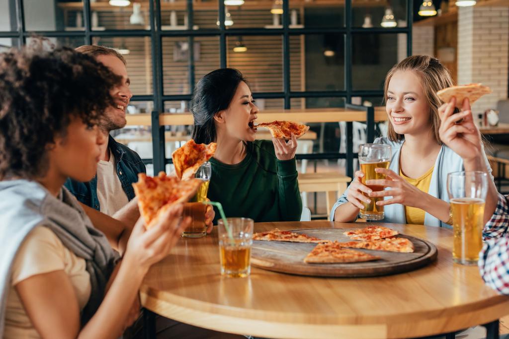 Amigos comiendo pizza en la cafetería
 - Foto, imagen