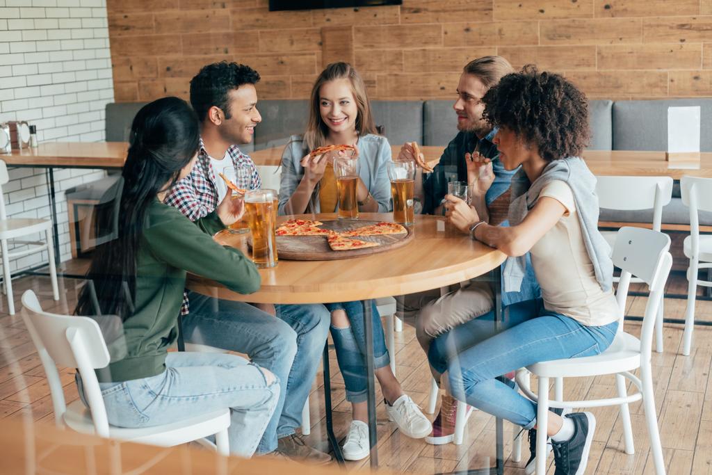 przyjaciele jedzenie pizzy z piwem w kawiarni - Zdjęcie, obraz