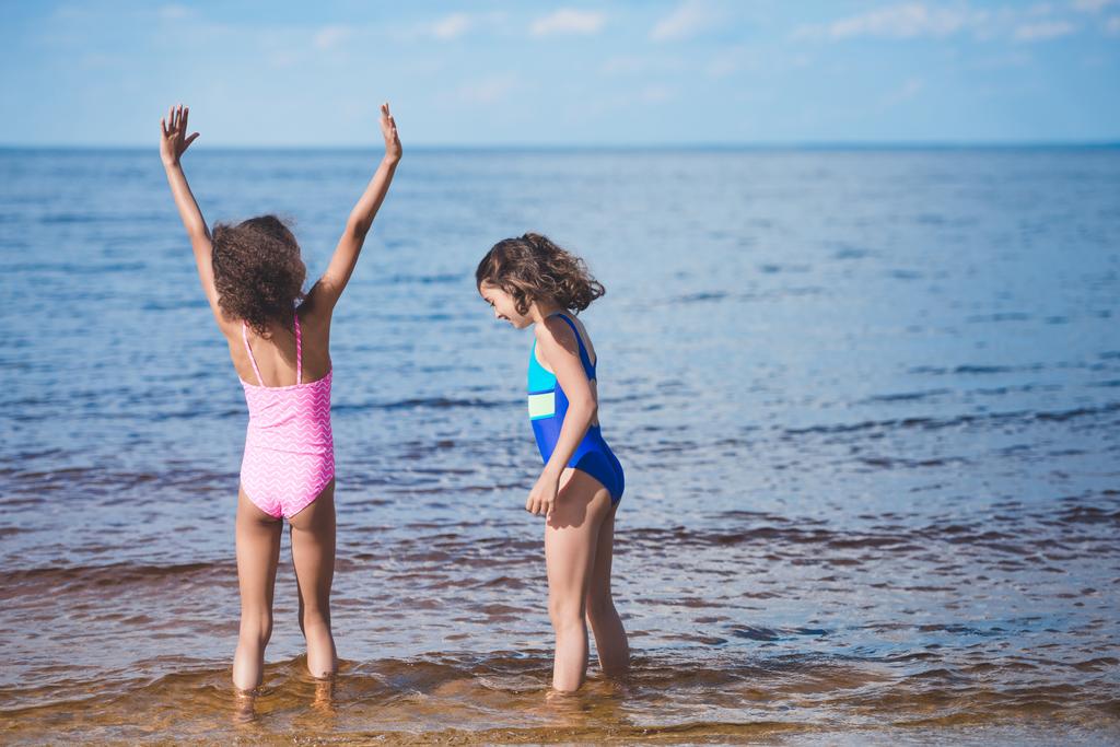 tytöt leikkivät meren rannalla
 - Valokuva, kuva