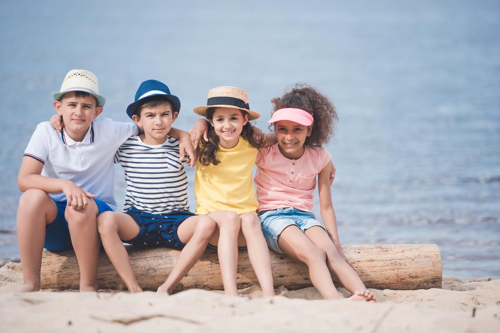 többnemzetiségű gyermek ült a tengerparton - Fotó, kép