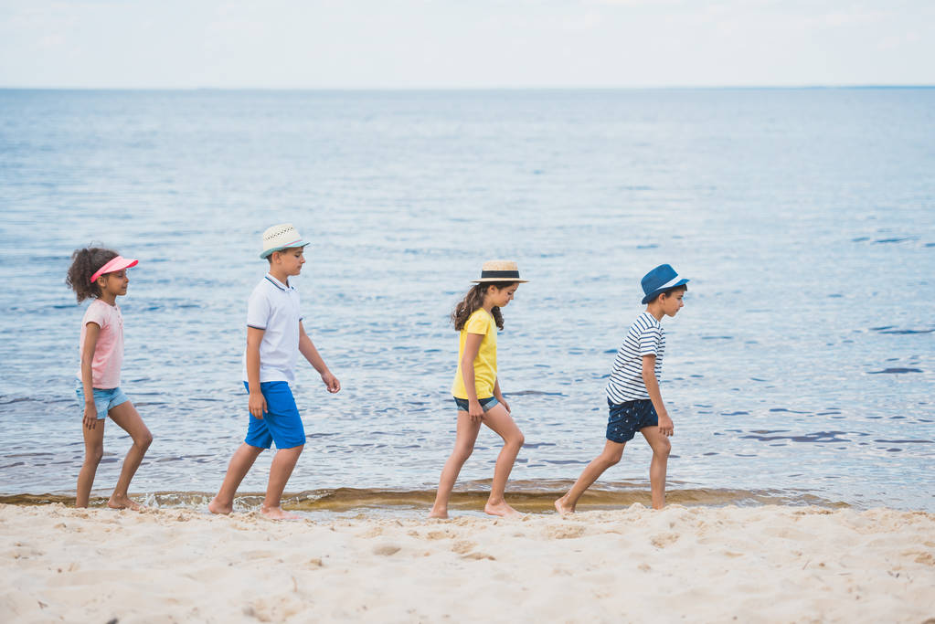 bambini multiculturali che camminano sulla spiaggia
 - Foto, immagini