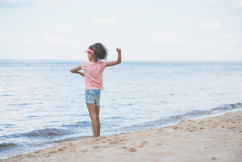афро-американських дівчинка, грає на березі моря - Фото, зображення