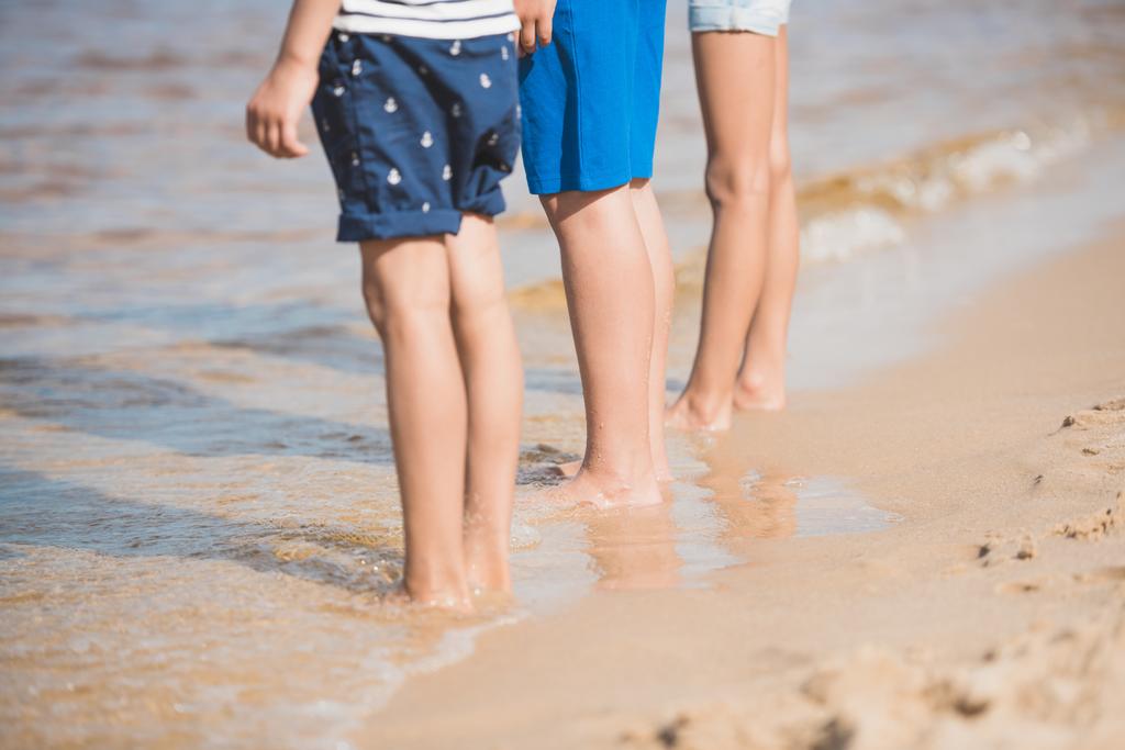 niños de pie a orillas del mar
 - Foto, imagen