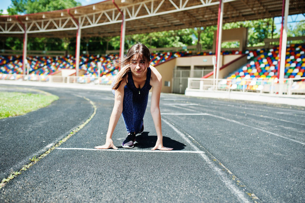 Retrato de uma garota forte em sportswear correndo no stadi
 - Foto, Imagem