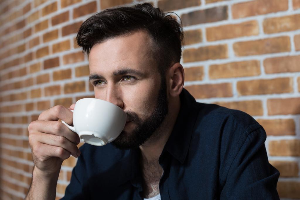 бородатий молодий чоловік п'є каву
 - Фото, зображення