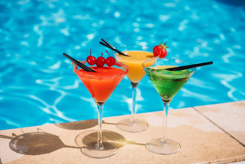 Värikkäitä cocktaileja uima-altaan lähellä
 - Valokuva, kuva