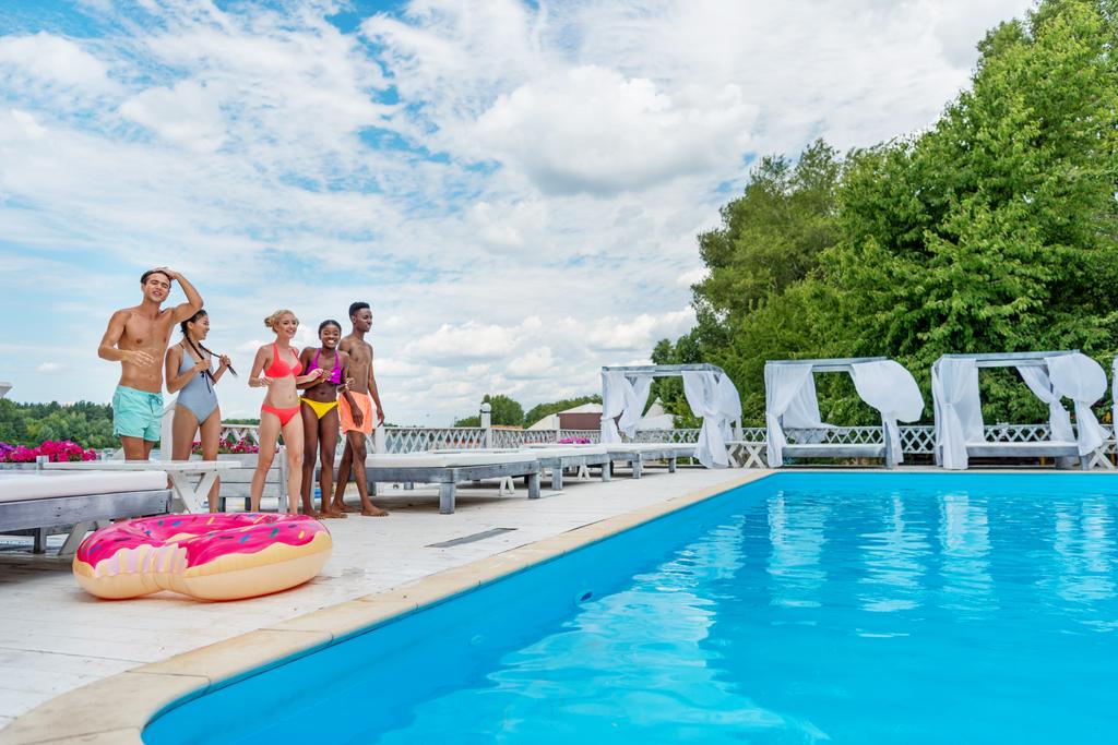 Wieloetniczny osób na wakacje w pobliżu basenu - Zdjęcie, obraz