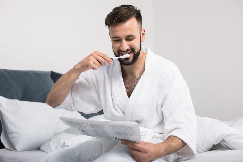 homme en peignoir brossant les dents
  - Photo, image