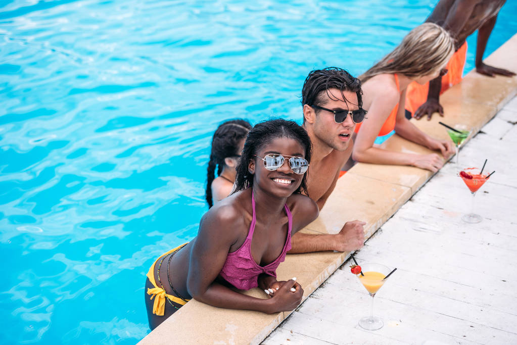 multiethnic people with cocktails in swimming pool  - Photo, Image