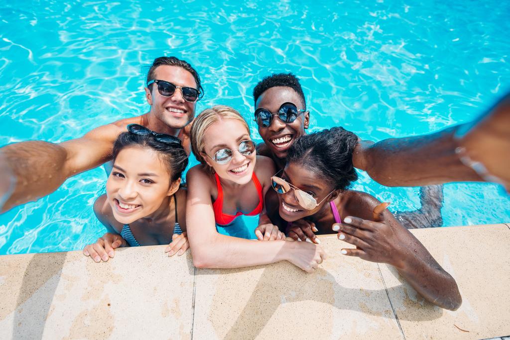 pessoas multiétnicas tomando selfie na piscina
  - Foto, Imagem