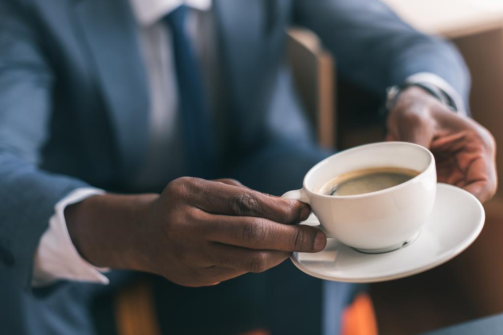 Бізнесмен тримає чашку кави
 - Фото, зображення