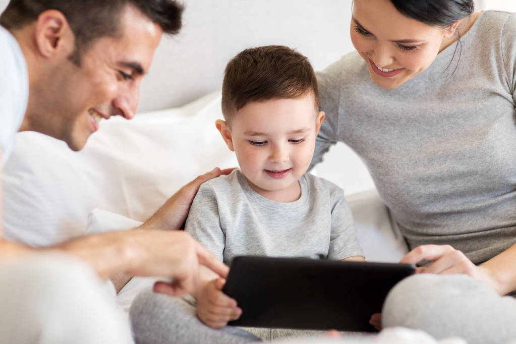 famille heureuse avec tablette PC dans le lit à la maison
 - Photo, image