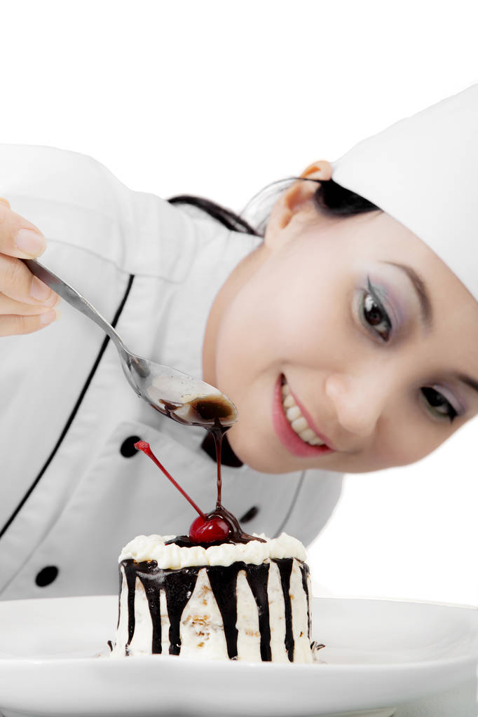 Прекрасный шеф-повар украшает сладкий торт
 - Фото, изображение