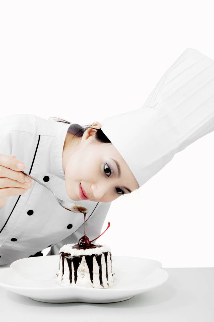 Жіночий шеф-кухар, що прикрашає смачний торт
 - Фото, зображення