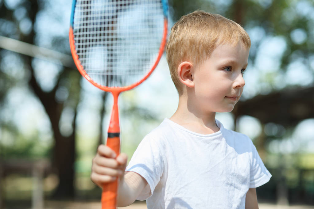 Petit garçon joue au badminton dans une pinède, repos actif dans une nature
 - Photo, image