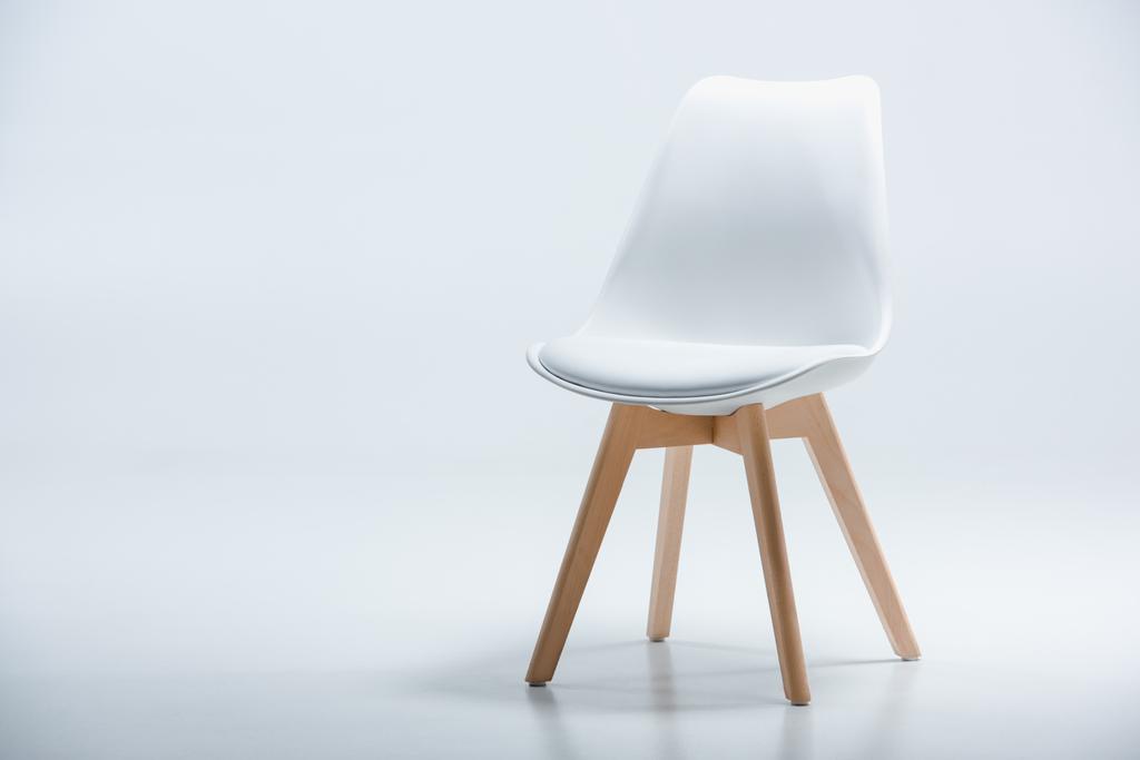 Beyaz üst ve ahşap ayaklı sandalye - Fotoğraf, Görsel