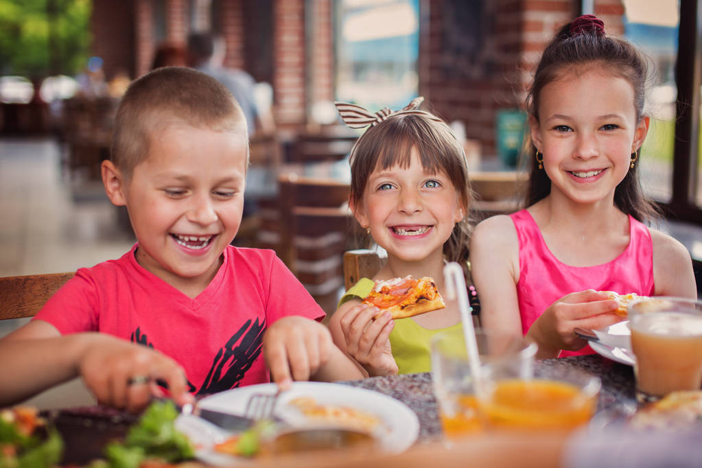 Ευτυχισμένα παιδιά τρώει πίτσα και να διασκεδάσουμε μαζί - Φωτογραφία, εικόνα