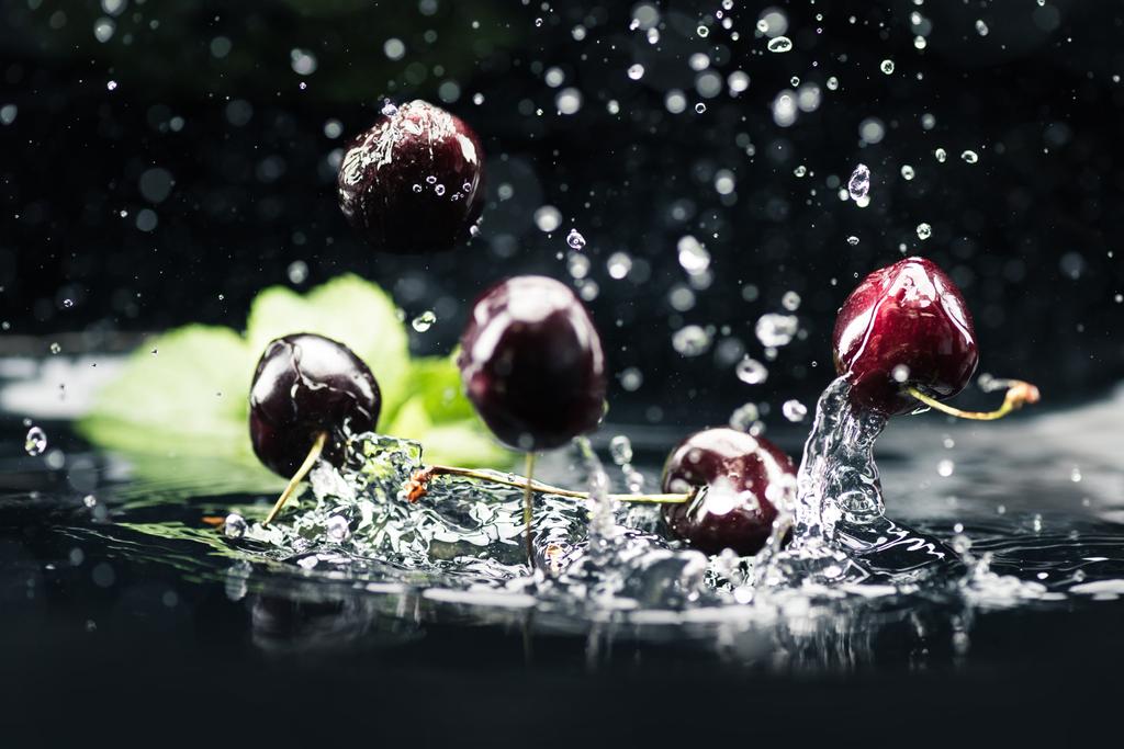 спелые вишни падают в воду
 - Фото, изображение