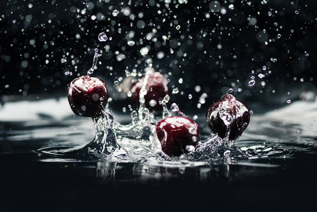 rijpe kersen vallen in water - Foto, afbeelding