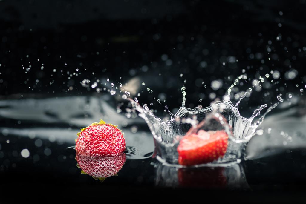 kypsiä mansikoita putoaa veteen
 - Valokuva, kuva