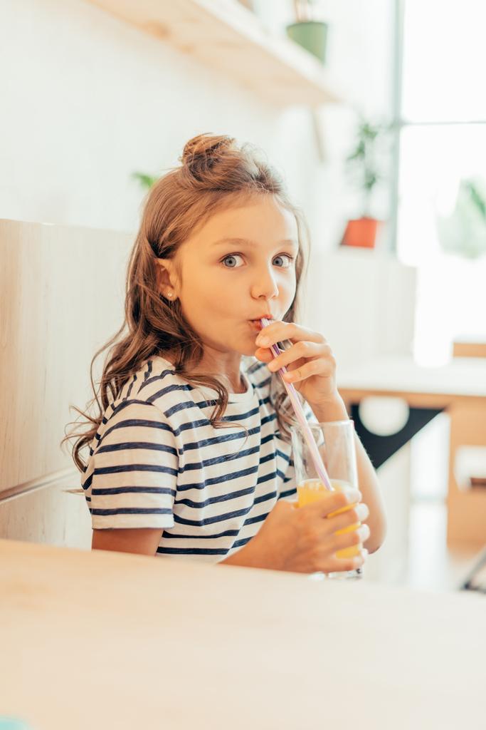 Маленька дівчинка п'є апельсиновий сік
 - Фото, зображення