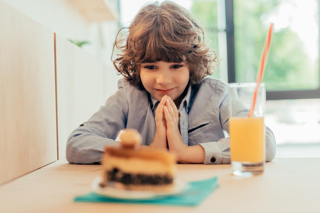 podekscytowany chłopczyk patrząc na ciasto - Zdjęcie, obraz