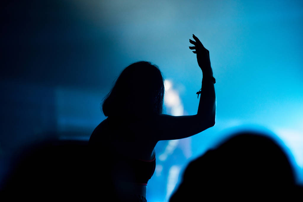 silueta de la multitud de conciertos frente a las luces del escenario brillantes - Foto, Imagen