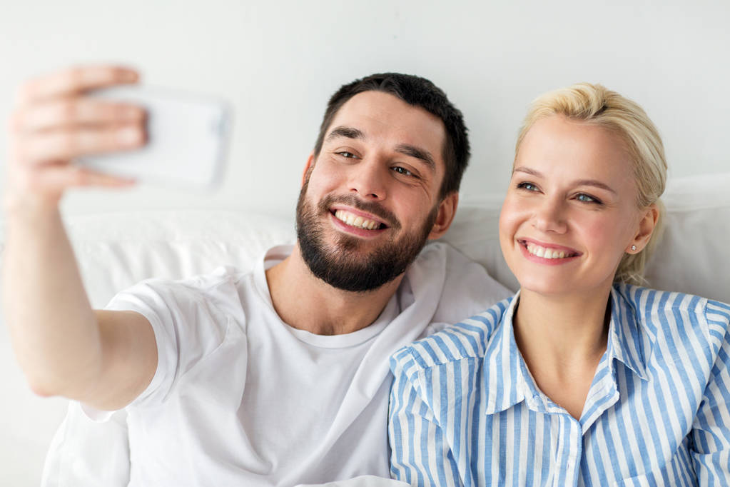 happy couple with smartphone taking selfie at home - Photo, Image