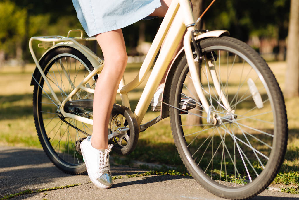 Bisiklet ile parkta oturan kız - Fotoğraf, Görsel