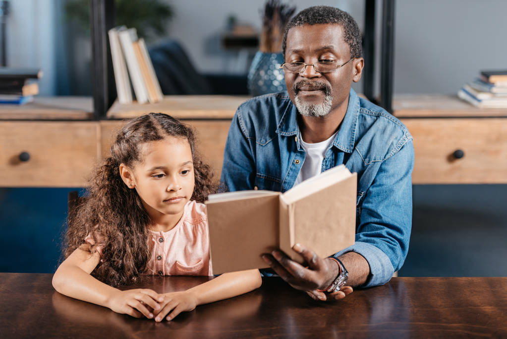 Africano americano homem lendo com filha
 - Foto, Imagem