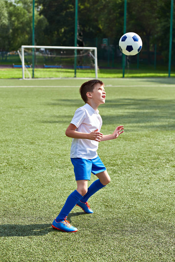 W piłkę nożną chłopiec z piłką - Zdjęcie, obraz