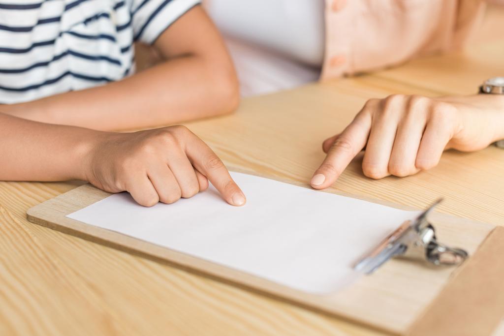 mulher e menino apontando para papel em branco
 - Foto, Imagem