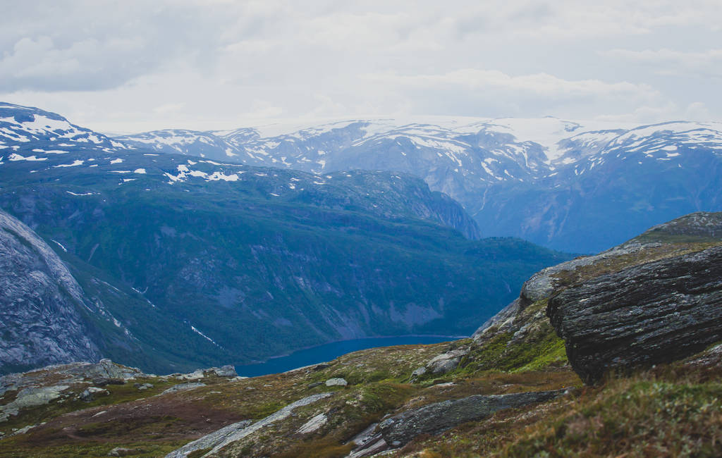Яркая картинка известного норвежского места для пеших прогулок - путь к троллям, троллям, скалам, скалам, с туристом, а также озеру Рингедалсватнет и горному панорамному пейзажу, Норвегия
 - Фото, изображение