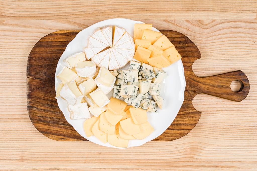 variedade de tipos de queijo na placa de madeira
 - Foto, Imagem