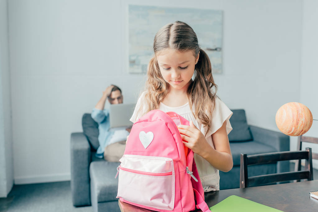 дівчина готує рюкзак для школи
 - Фото, зображення