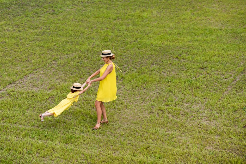 mãe e filha andando no gramado
 - Foto, Imagem