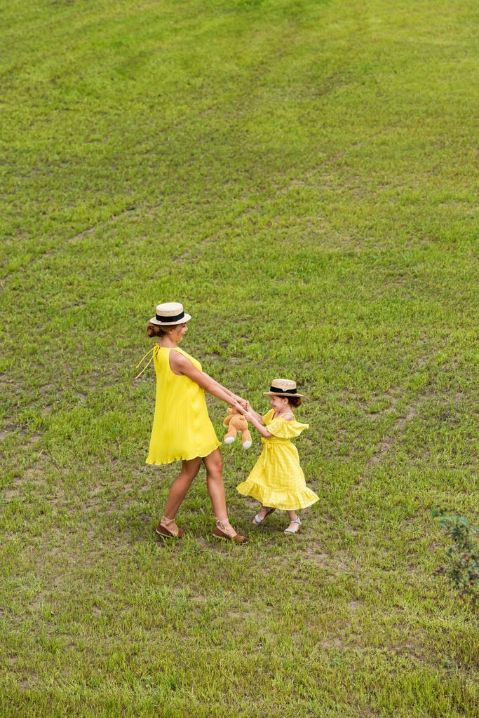mother and daughter walking on lawn - Photo, Image