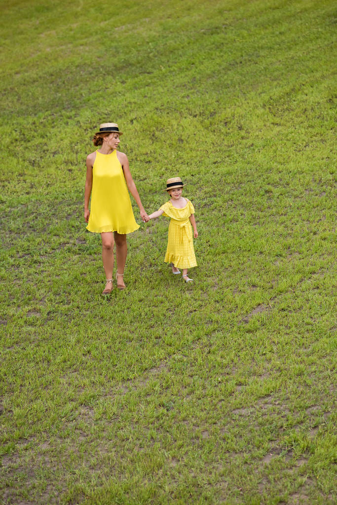 madre e hija caminando sobre el césped
 - Foto, imagen