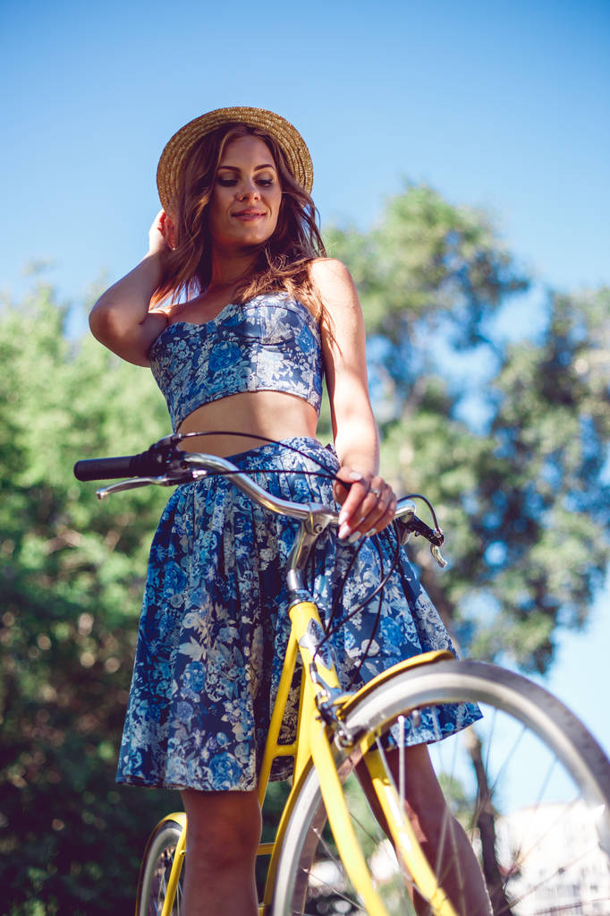 Gros plan portrait de souriante jeune femme caucasienne et la roue d'un vélo
 - Photo, image