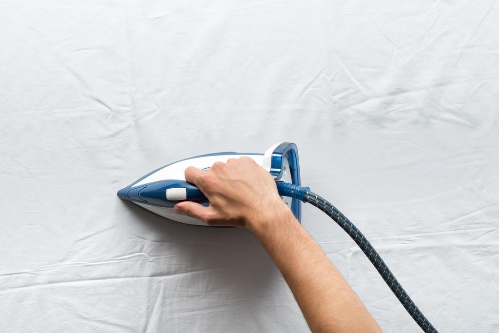 man ironing bed sheets - Photo, Image