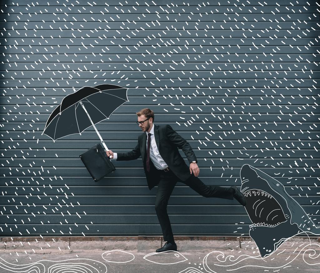 Businessman running with umbrella - Photo, Image