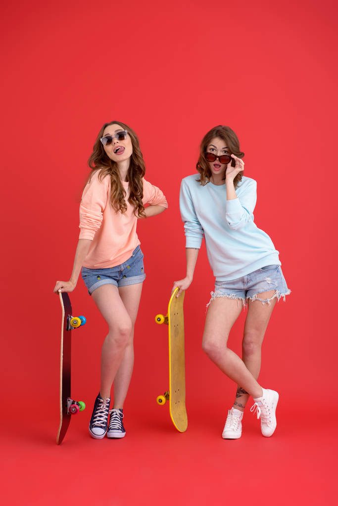 幸せな 2 人の女性お友達とスケート ボードを保持. - 写真・画像