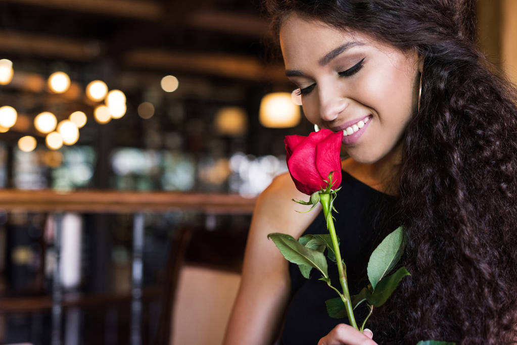 vrouw met roos in restaurant - Foto, afbeelding