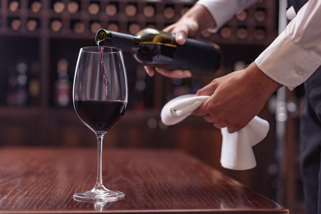 Сомелье разливает красное вино
 - Фото, изображение